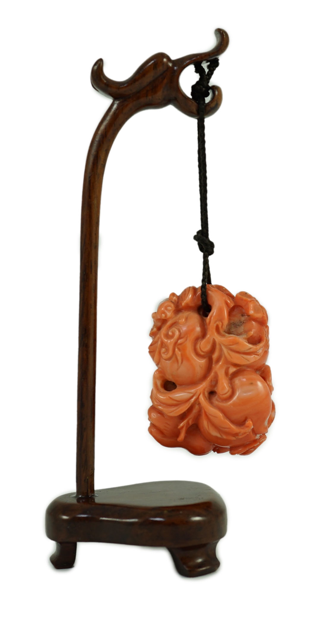 A good Chinese coral ‘fruit and bats’ pendant, 19th century, 3.7cm, later suspension stand